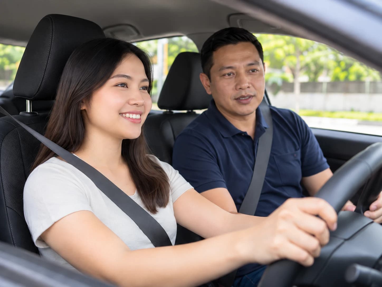Illustrative driving lesson with a learner and instructor wearing seatbelts